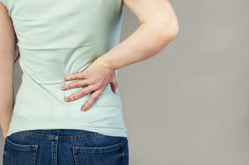 Woman with back pain holding her aching back - body pain
