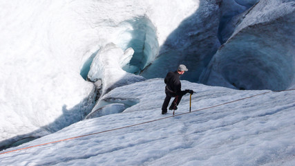 mountain climber training rope and ice axe skills on the glacier ice in the Alps near Pontresina
