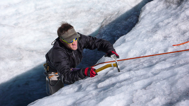 young mountain guide showing and doing training for ice and rope skills on a glacier in the Alps