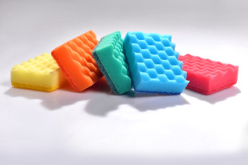 Multicolored sponges for washing dishes on white background. Cleaning the house. Studio shooting accessories for the kitchen.
