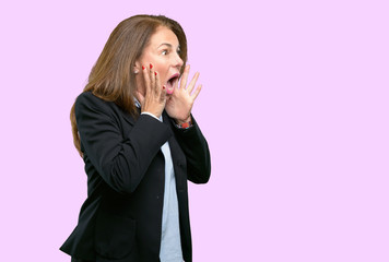 Middle age business woman stressful keeping hands on head, terrified in panic, shouting