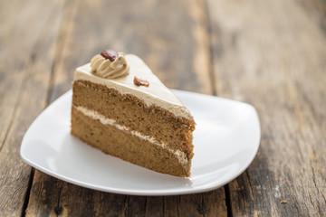 chocolate cake slice with almonds on plate on wooden table