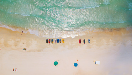 Aerial : Overhead  of people enjoying the summer at sand  beach ,waves breaking against the coast...