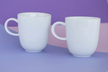 Minimalist cup Mockup.white cups on a  graphic background . cup on trend lilac pink geometric background. copy space.tableware mockup.