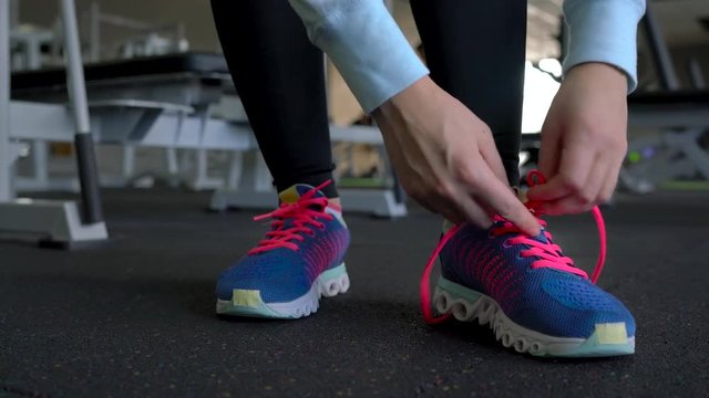 Running shoes - woman tying shoe laces in the gym