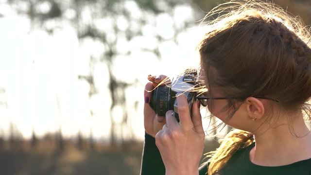 Beautiful girl takes pictures of her beloved man on a film camera. Slow motion