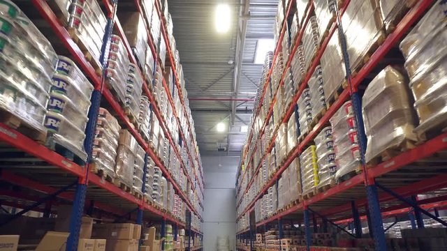 Long storage corridor between rows of shelves with goods