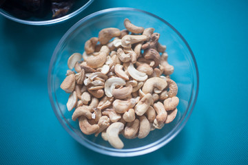 Cashew nuts in a transparent Cup on the table.