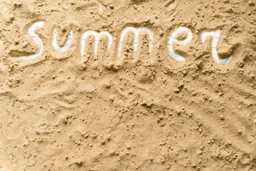 Summer inscription on a sandy background. The concept of travel