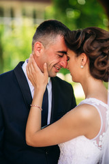 Beautiful couple walking in the park in their wedding day. Sunny weather