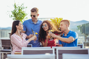 Friends having fun and drinking cocktails outdoor on a penthouse balcony