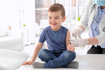 Doctor vaccinating little boy in hospital