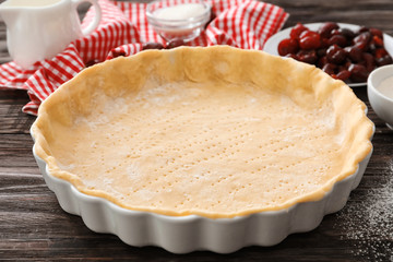 Baking pan with unbaked crust for cherry pie on kitchen table