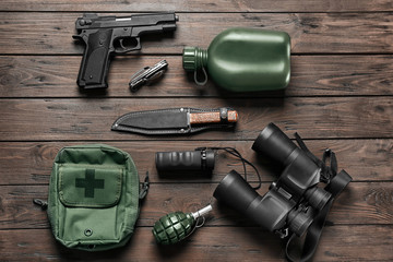 Obraz premium Set of military outfit on wooden background, flat lay