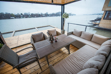 Rest place wit hsofas on balcony of cottage near river