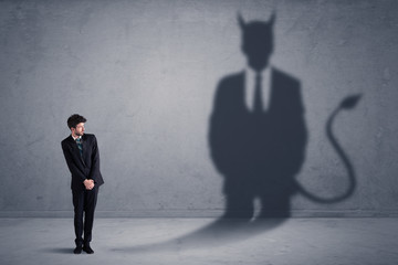 Obraz premium Business man looking at his own devil demon shadow concept background