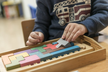 Child is playing with wooden colorful toys