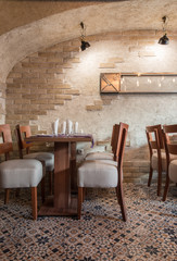 Old brick wall and setting tables in restaurant
