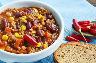 chili con carne on white bowl and Black bread or Rye bread