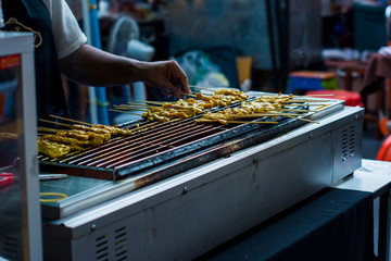 HaTraditional yakitori chicken stand in asian at street food vendor market, grilled satay in Thailand, Asian food stylend of cooking satay grill.