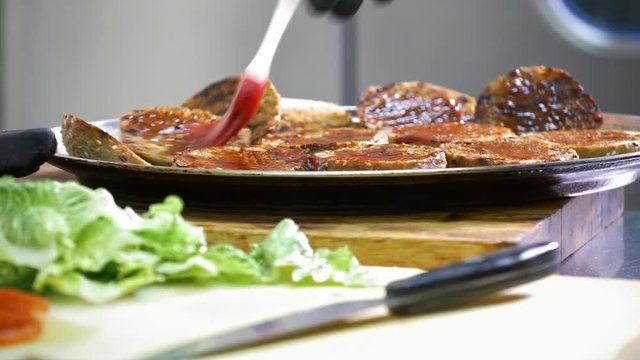 Hands of chief on commercial kitchen serves fried bread
