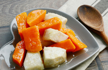 Sweet potatoes and Taro Thai Menu.
Sweet potatoes and Taro in syrup in heart shape dish on wooden background.
