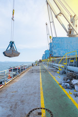 Fototapeta na wymiar the process of Lignite coal in freight discharge form bulk cargo ship anchor.