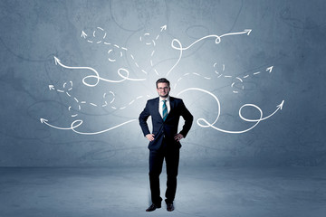 Elegant businessman choosing between directions with winding drawn arrows around 
