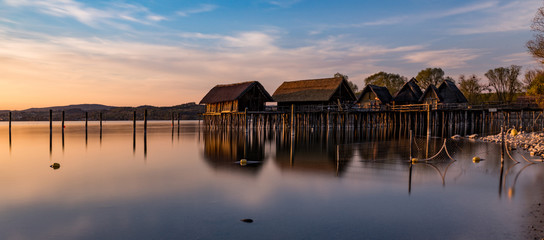 Colorfull sunset at Lake Dwellings of the Stone and Bronze Age in Unteruhldingen on Lake Constance, Baden-Wurttemberg - obrazy, fototapety, plakaty