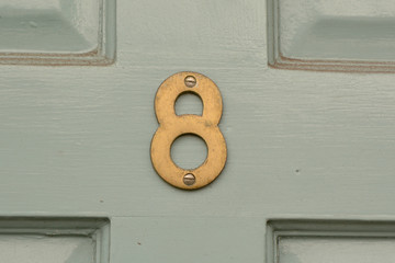 House number 8 sign on door painted green