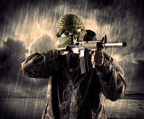 Portrait of a dangerous armed terrorist with mask and gun in a thunderstorm with lightning