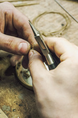 jeweler produces gold jewelry in the workshop