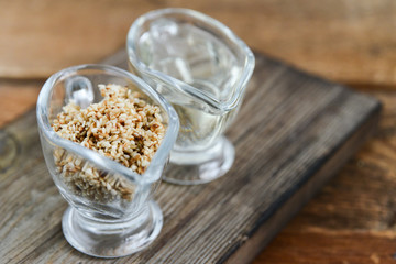 sesame seed oil and sesame seed oil in glass Cup on natural wooden background, healthy food concept, organic food.