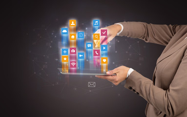 Female elegant hand holding tablet with colourful application icons