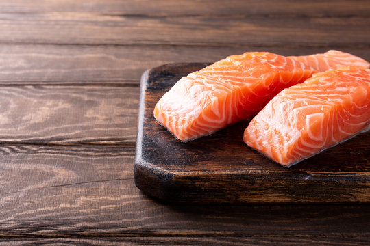 Fresh raw salmon fillet. Old wooden background. Copy space. Selective focus.