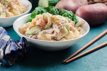 Delicious potato salad with ham, egg and cucumber