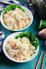 Delicious potato salad with ham, egg and cucumber