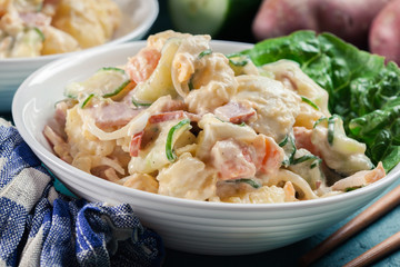 Delicious potato salad with ham, egg and cucumber