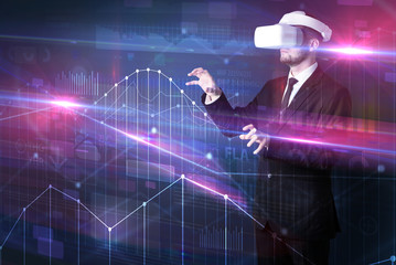 Businessman with virtual reality goggles organizing 3D graphs charts and financial variables
