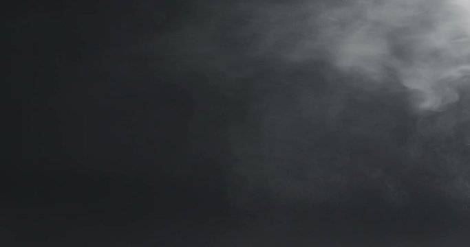 slow motion vapor steam over black background