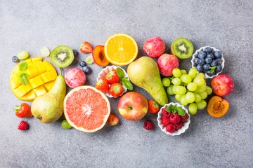 Zelfklevend Fotobehang Overhead shoot with fresh assorted fruits and berries on light gray background. Colorful clean and healthy eating. Detox food. Copy space. Top view. © Iryna Melnyk