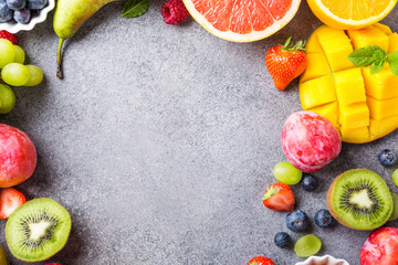 Overhead shoot with fresh assorted fruits and berries on light gray background. Colorful clean and healthy eating. Detox food. Copy space. Top view.