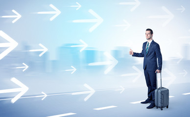 Young businessman hitchhiking near the city with arrows around concept