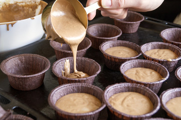 Women's hands preparing homemade chocolate cupcakes.