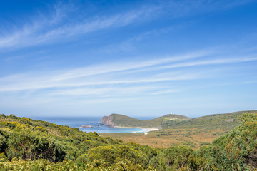 Beautiful view from light house station to stunning rocky cliffs bay and deep blue water of southern ocean on warm sunny day with blue sky after hiking to South Cape, Bruny Island, Tasmania, Australia