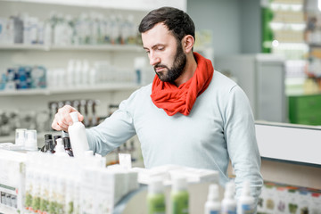 Man looking for medicaments in the pharmacy store