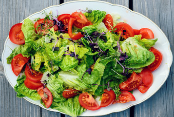 mixed summer salad on wooden ground