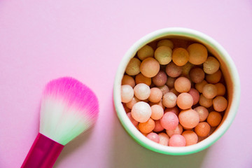 Obraz na płótnie Canvas pink blush brush and powder in beads on pink background