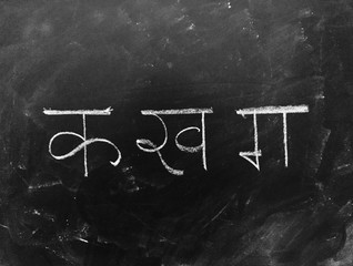 Hindi Script Handwritten on Blackboard. Translation: Written hindi script letter as 
