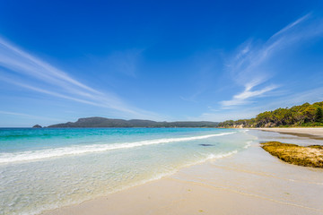 Amazing view to great paradise island sandy beach with turquoise blue water and green shore jungle forest on warm sunny clear sky relaxing day, River Adventure Bay, Bruny Island, Tasmania, Australia